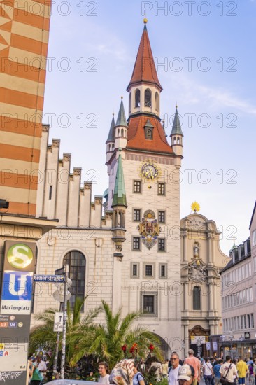 Historic tower with clock in a lively urban environment under a clear sky, Munich, Germany