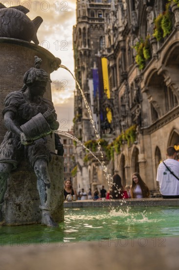 Fountain with sculpture and flowing water in front of the New Town Hall, Munich, Germany