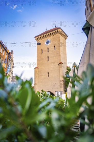 Historic clock tower in an urban setting with blue sky, Munich, Germany