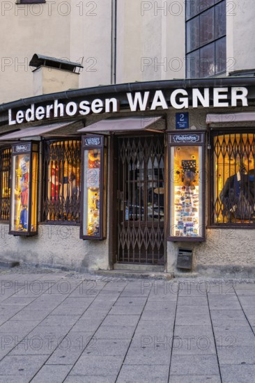 Traditional shop for lederhosen with illuminated shop window, Munich, Germany