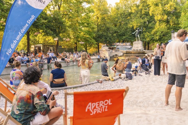 Summer atmosphere with numerous people at the fountain, Munich, Germany