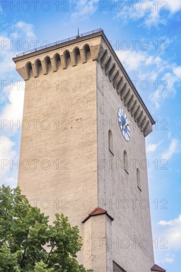 Historic clock tower with clock face in front of a blue sky, Munich, Germany