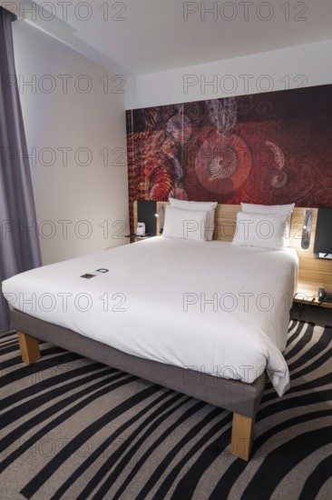 Modern hotel room with comfortable double bed, stylish decoration and elegant furnishings, Munich, Germany