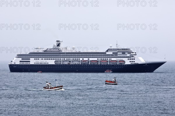 Cruise ship at sea with several small excursion boats for whale watching, Husavik, Iceland