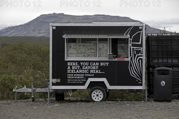 Food truck in the car park at Brúarfoss waterfall in the countryside with opening hours from 11 am to 5 pm, South Iceland, Iceland
