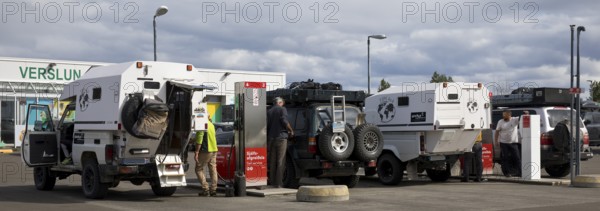 Several off-road vehicle drivers refuelling at self-service petrol stations, Reykjalith, Myvatn, Iceland