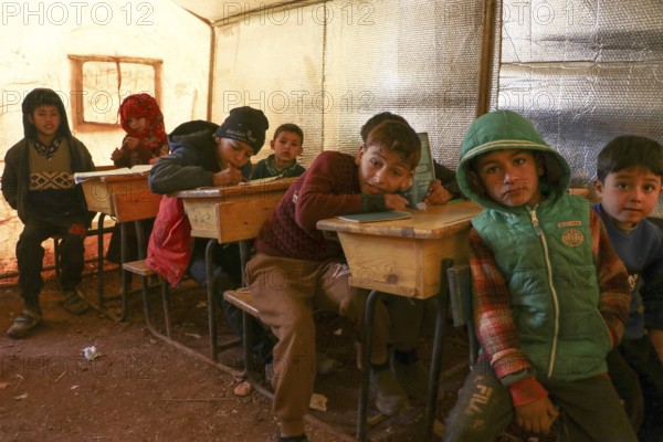 Syrian refugee children sitting inside a tent classroom, receiving basic education despite displacement and conflict. Aleppo, Syria January 18, 2022, Aleppo, Syria