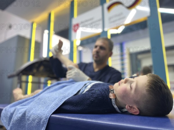 A displaced Syrian child receiving physical therapy from a physiotherapist after a war injury. Aleppo, Syria October 29, 2022, Aleppo, Syria