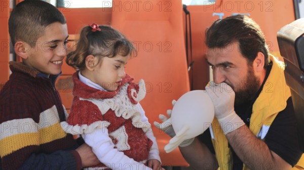 Displaced Syrian children receiving urgent medical intervention inside an ambulance, reflecting the medical situation during the Syrian war. Aleppo, Syria. June 24, 2015, Aleppo, Syria