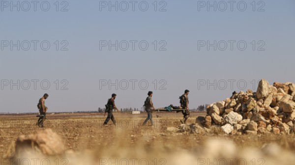 Military fighters carrying a wounded man injured during a battle against ISIS in northern Syria. Aleppo, Syria October 16, 2016, Aleppo, Syria