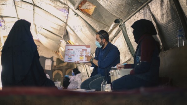 A community health worker giving instructions to refugees on how to deal with the cholera outbreak that spread in Syrian refugee camps. Aleppo, Syria. October 29, 2022, Aleppo, Syria