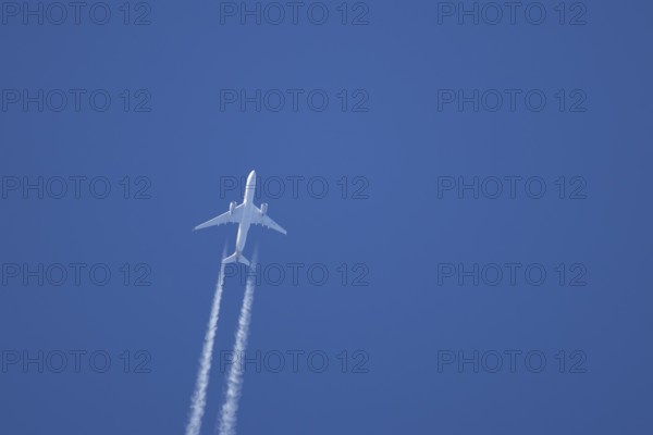 Airbus A350-900 passenger jet aircraft of Singapore airlines flying with a vapour trial or contrail behind in a blue sky, England, United Kingdom