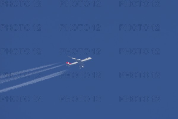 Boeing 747 jumbo jet cargo aircraft of Cargolux airlines with a vapour trail or contrail flying in a blue sky, England, United Kingdom