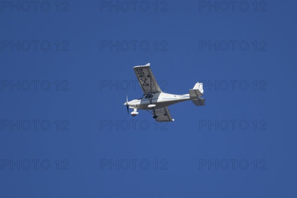 Evektor SportStar light aircraft flying in a blue sky, England, United Kingdom