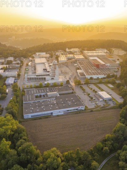 Industrial area surrounded by forests and hills in the evening light of the sunset, industrial area Wolfsberg Nagold, district Calw, Black Forest, Germany