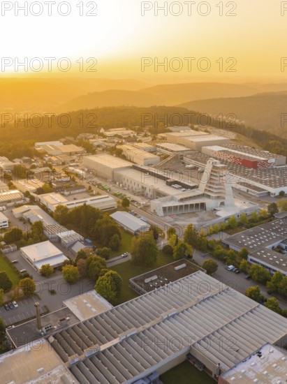 Industrial complex at sunset surrounded by hills and forests, industrial area Wolfsberg Nagold, district Calw, Black Forest, Germany