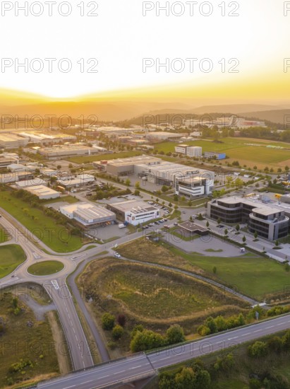 Industrial area in the sunset, surrounded by fields and forests with modern buildings, industrial area Wolfsberg Nagold, district Calw, Black Forest, Germany