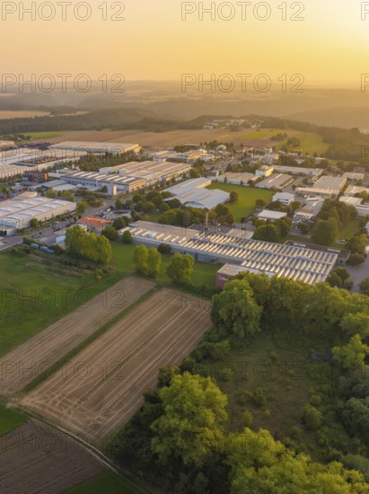 Aerial view of a rural industrial plant with fields and trees at sunset, industrial area Wolfsberg Nagold, district Calw, Black Forest, Germany