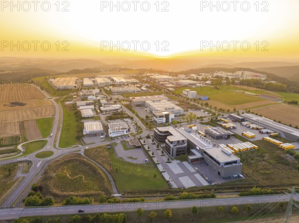 Industrial park at sunset, with symmetrical streets and a mixture of fields and buildings, industrial area Wolfsberg Nagold, district Calw, Black Forest, Germany