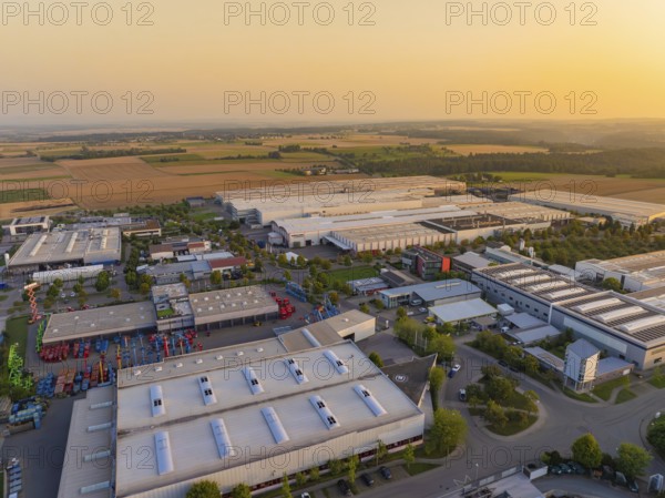 Close-up of an industrial area with buildings and fields in an urban environment at sunset, industrial area Wolfsberg Nagold, district Calw, Black Forest, Germany