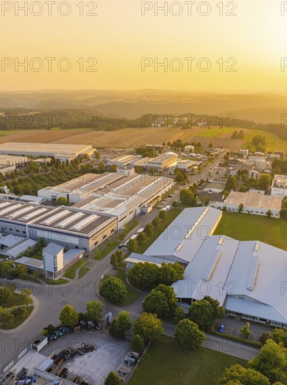 Industrial area at sunset with fields and green areas in the background, industrial area Wolfsberg Nagold, district Calw, Black Forest, Germany