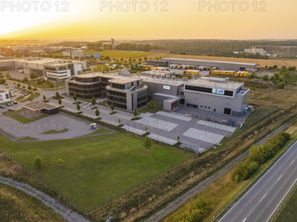 Commercial area with modern buildings and streets in a rural setting in the evening, industrial area Wolfsberg Nagold, district of Calw, Black Forest, Germany