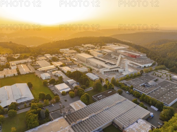 Extensive industrial complex embedded in wooded hills at sunset, industrial area Wolfsberg Nagold, district of Calw, Black Forest, Germany