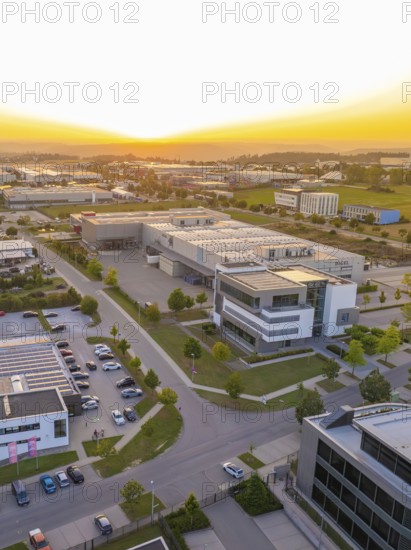 Industrial area at sunset with modern buildings, orderly streets and car parks, industrial area Wolfsberg Nagold, district Calw, Black Forest, Germany