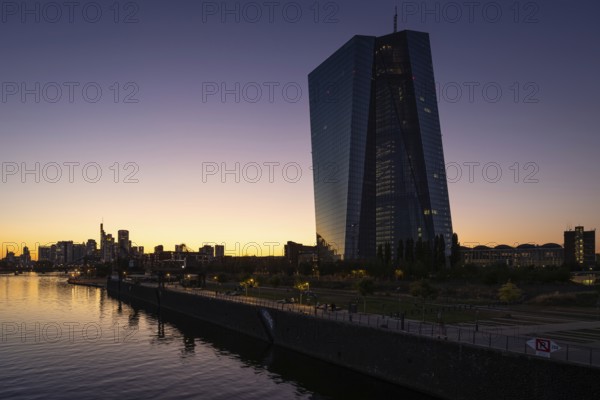 The sun sets behind the European Central Bank (ECB) and the Frankfurt banking skyline, Frankfurt am Main, Hesse, Germany