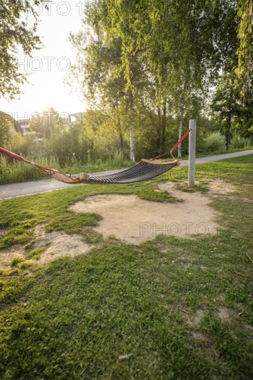 A hammock between trees in a green park at sunset, Nagold, district of Calw, Black Forest, Germany
