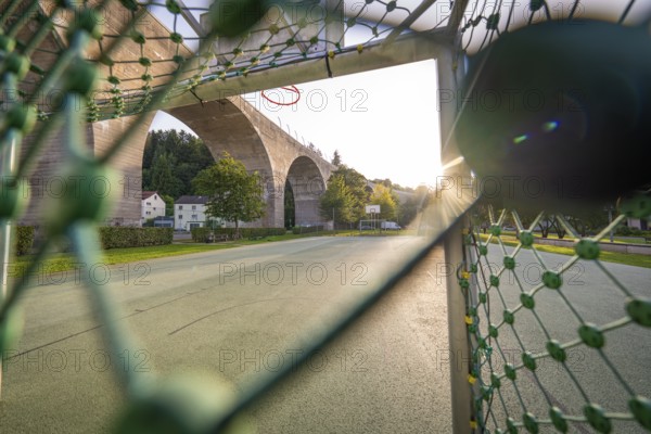 Playground with basketball hoop and a large bridge in the evening sunlight, Nagold, Calw district, Black Forest, Germany
