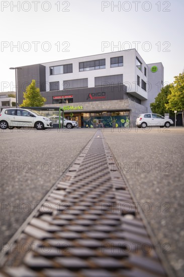 Modern commercial building with cars in a car park in an urban environment, Nagold, district of Calw, Black Forest, Germany