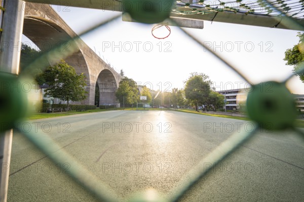 View over a sports field with basketball hoop in the morning light, framed by trees, Nagold, district of Calw, Black Forest, Germany