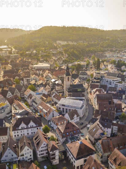 View of an urban area with church and old houses in the evening sun, surrounded by hills, Nagold, district of Calw, Black Forest, Germany