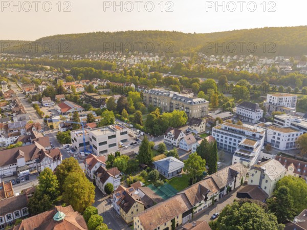 Urban environment with residential buildings and many trees, rising hills in the background in autumn light, Nagold, district of Calw, Black Forest, Germany