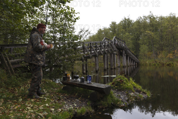 Tourist at the bridge over the Drosedower Bek, Müritz National Park, Mecklenburg-Western Pomerania, Germany