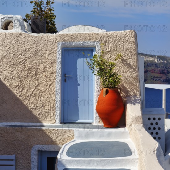 Red vase in front of a yellow wall, light blue door, holiday home, Oia, Thira, Santorini, Cyclades, Greece