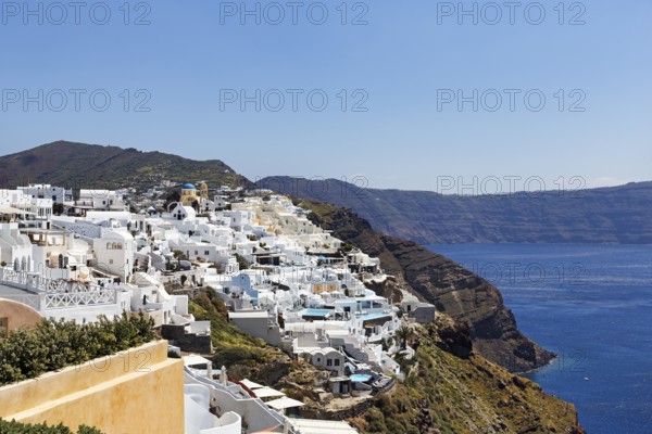 White and colourfully painted holiday homes, orthodox church with blue dome on the edge of the caldera, cliffs, Oia, Thira, Santorini, Cyclades, Greece