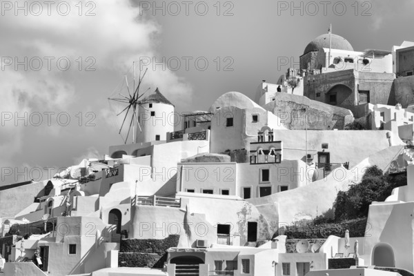 Typical cube-shaped holiday homes and windmill on a steep slope, Cumulus, monochrome, Oia, Thira, Santorini, Cyclades, Greece