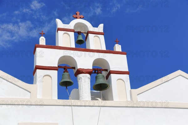 Bell tower of an orthodox church in typical Cycladic architecture with whitewashed walls and red crosses, Old Town, Oia, Thira, Santorini, Cyclades, Greece