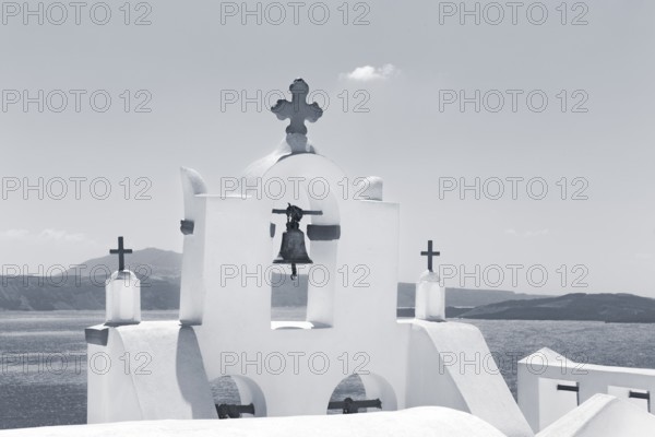 White bell tower of an orthodox church by the sea, monochrome, Oia, Thira, Santorini, Cyclades, Greece
