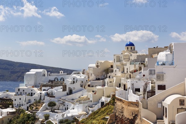 White holiday homes, orthodox church with blue dome on the edge of the caldera, Cumulus, Oia, Thira, Santorini, Cyclades, Greece