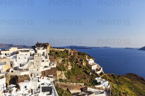 White houses on a cliff, castle of St Nicholas, Agios Nikolaos, view of the caldera, Oia, Thira, Santorini, Cyclades, Greece