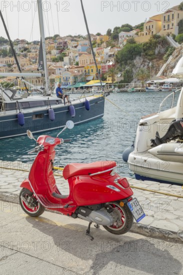 Red vespa scooter parked at Gialos harbour, Gialos, Symi Island, Dodecanese Islands, Greece