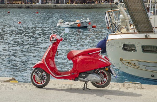 Red vespa scooter parked at Gialos harbour, Gialos, Symi Island, Dodecanese Islands, Greece