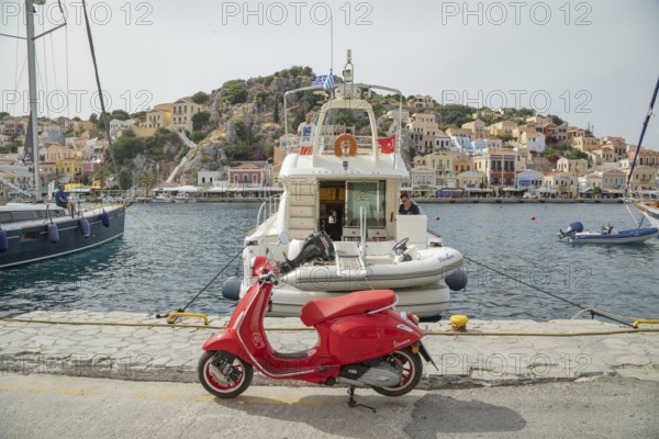 Red vespa scooter parked at Gialos harbour, Gialos, Symi Island, Dodecanese Islands, Greece