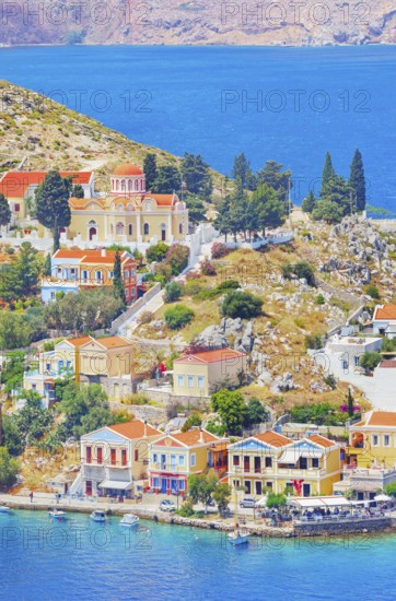 Colourful houses and Evangelismos church at the Harani Bay, Gialos, Symi Island, Dodecanese Islands, Greece