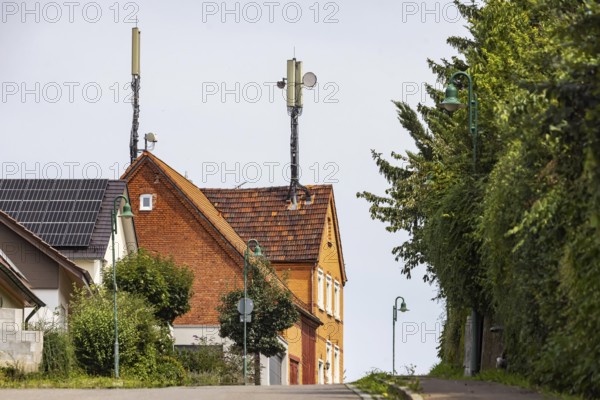 Mobile phone mast on a house roof in a rural area. Ohmden, Baden-Württemberg, Germany
