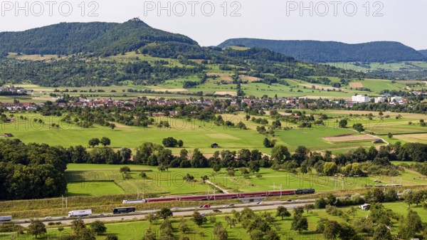 A8 motorway near Kirchheim unter Teck. The route of the new high-speed railway line from Stuttgart to Ulm runs parallel to the road. Regional train RE200. The Swabian Alb with Teck Castle in the background. Kirchheim unter Teck, Baden-Württemberg, Germany