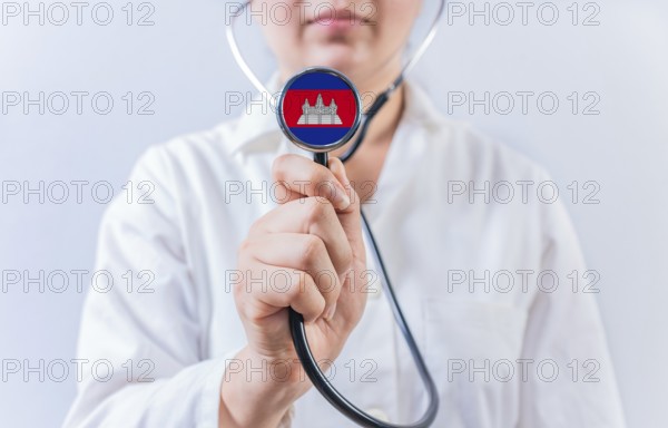 Female doctor holding stethoscope with Cambodia flag. National health system of Cambodia